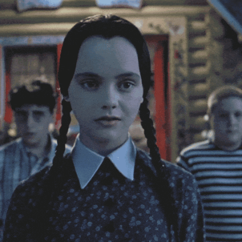 Wednesday Addams Forced Smile GIF