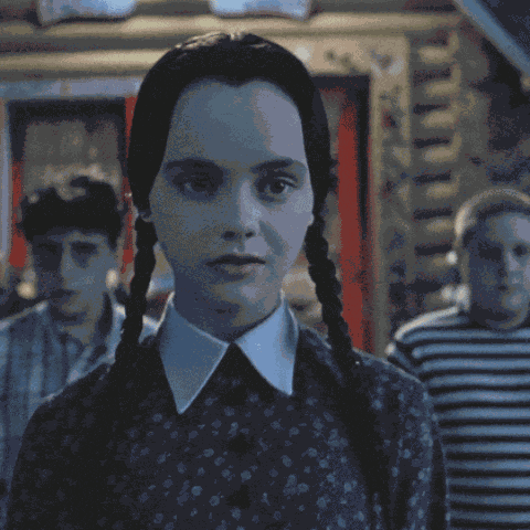 Wednesday Addams Forced Smile GIF